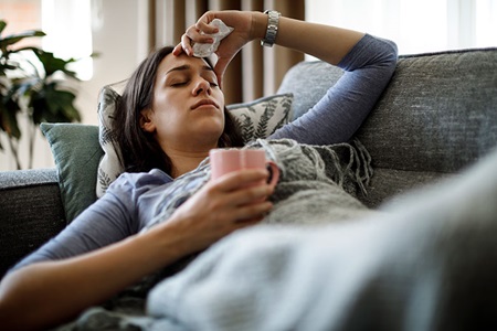 Woman lying on the couch sick