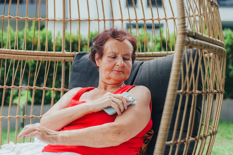 Woman tests glucose levels while lounging in chair