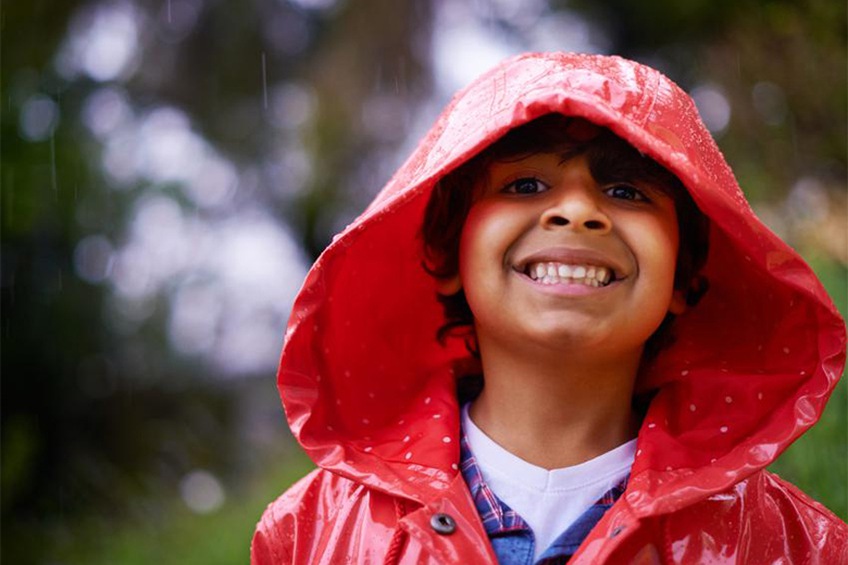 Kid smiling in the rain