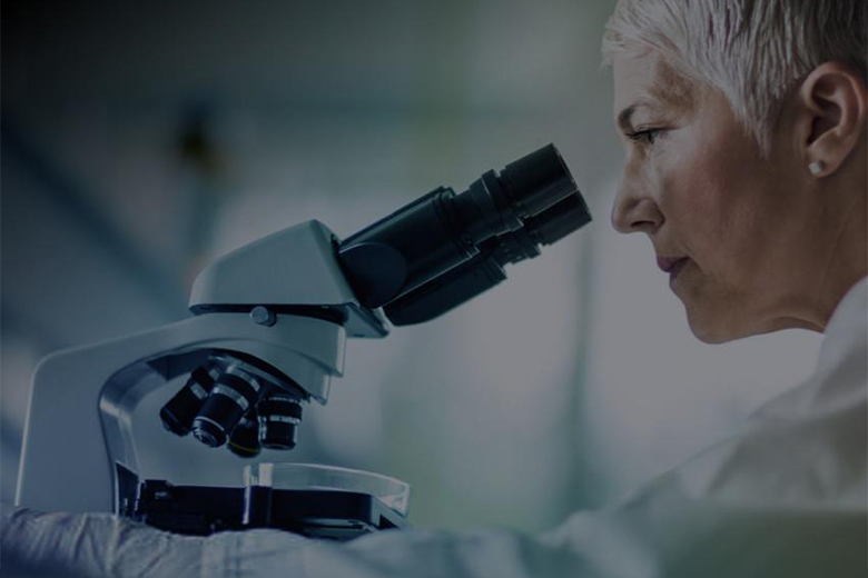 Researcher looking through a microscope