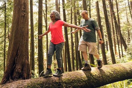 Couple walking on a fallen tree